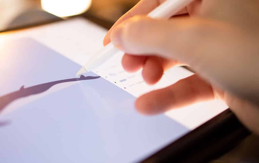 Graphiste_et_nomade_digital_dessinant_sur_son_iPad graphiste et nomade digital dessinant sur son iPad